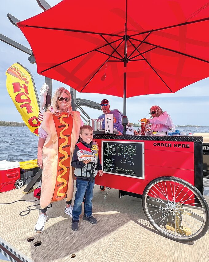 Hux Broten smiles as he gets a hot dog while out fishing with his grandparents on Pike Bay on Saturday. The new floating hot dog stand proved a hit on opening day.