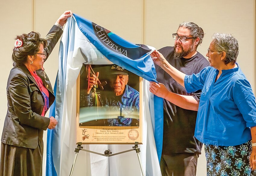 Dianna Goodsky-Hertig, left, Tom Spears and Lela Goodsky Correa unveil the portrait and plaque honoring their father, the late Bois Forte elder and spiritual advisor Gene Goodsky.