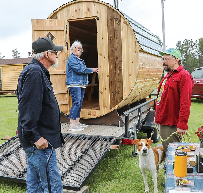 Attendees take an   inside look at a barrel sauna on display and for sale.