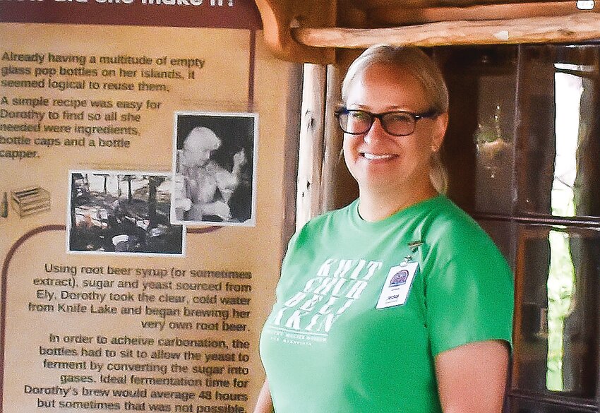 Jess Edberg, executive director of the Dorothy Molter Museum, at the   newly-opened root beer exhibit on the porch of Molter&rsquo;s Winter Cabin.