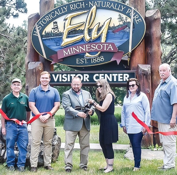 Rep. Roger Skraba and Ely Mayor Heidi Omerza wield the scissors to cut the ribbon on Midco&rsquo;s new fiber optic network in Ely. Also pictured are (l-r) David Sebesta, John Eloranta, Angela Campbell, and Paul Kess.