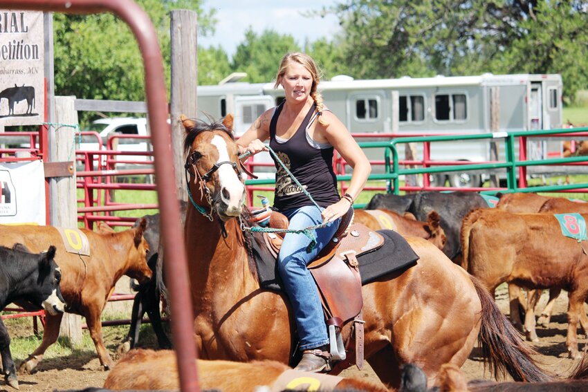 Pam Frazee demonstrates her riding skills in the team penning events.