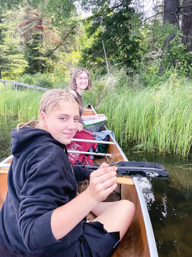 Lauren Rehbein (background) and Sylvia Shock (foreground) trapping crayfish on the Burnstside River.