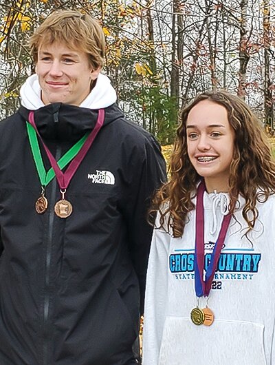 Caid Chittum and Molly Brophy pose with their medals from cross country sectional competition.