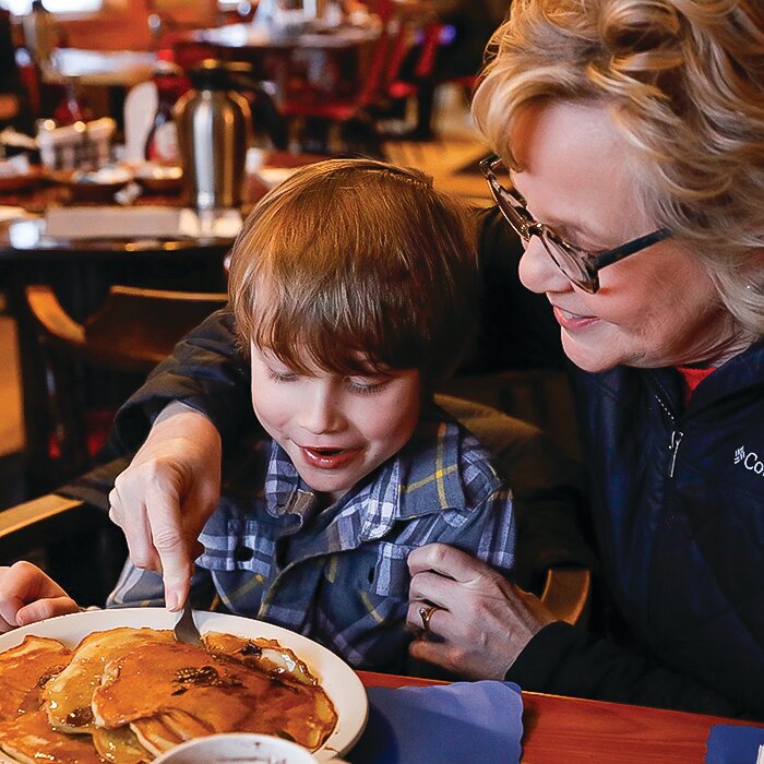 Six-year-old William Meehan, of Esko, gets some help from his grandmother Diane as he attempts to finish the large plate of chocolate chip pancakes