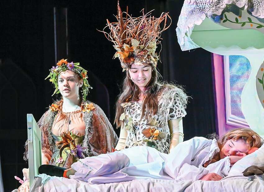 Ely freshman Chezne Nickolson (left) and Ely sophomore Molly Lindsay (center) play the troll couple Bulda and Pabbie, looking upon Ely sixth grader Beck Sponholtz, who plays a younger Princess Anna who had just been cured of her magical injury at the hands of her sister, Princess Elsa.