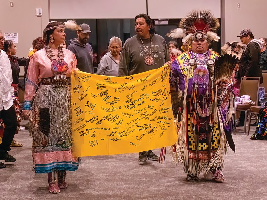 Elizabeth Francis and Curt Moon carried a banner during the Grand Entry with names of those seeking encouragement during their healing journey.