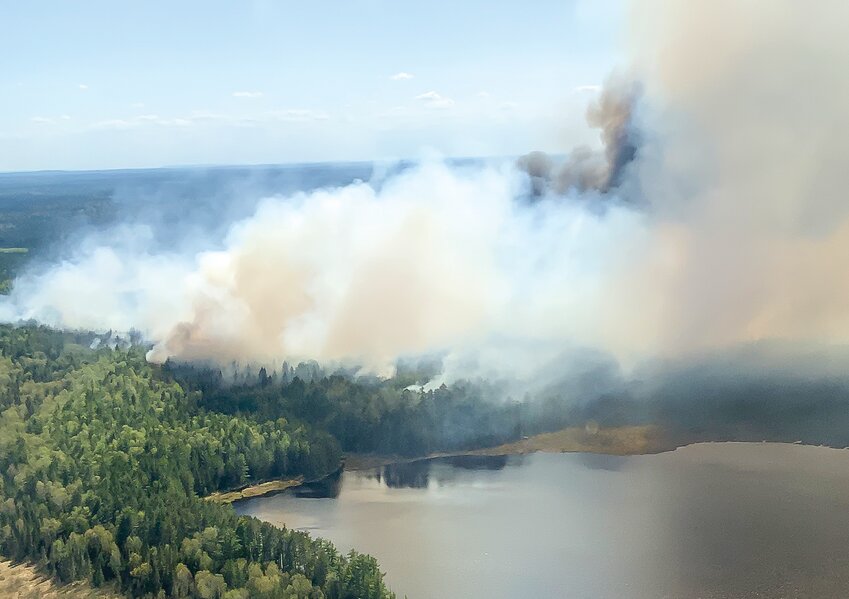 Smoke rises over Bezhik Lake during a wildfire in the spring of 2021. Wildfires have become   increasingly intense in the North Country in recent decades as a   result of a warming climate.