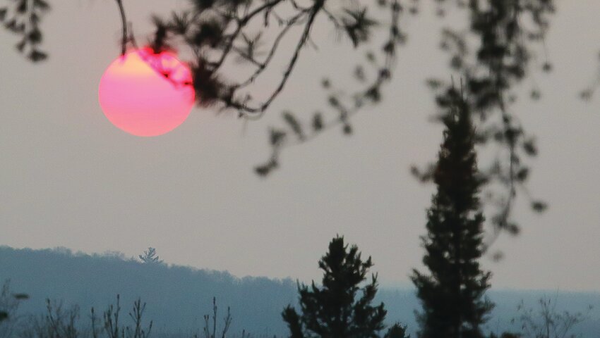 A red sun sets through smoky skies last Sunday evening as dense wildfire smoke from   Canada moved into the region.