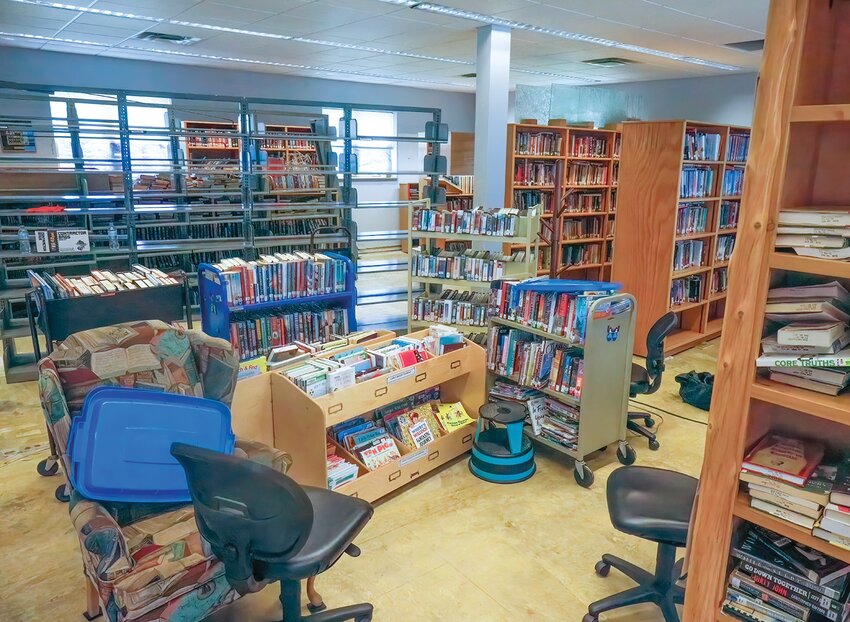 A sticky tile floor, carts of books and empty shelves are all signs of the volunteer response to the six inches of water that seeped into the building during the flood. Removing the waterlogged carpet quickly was essential for protection the library's collection.