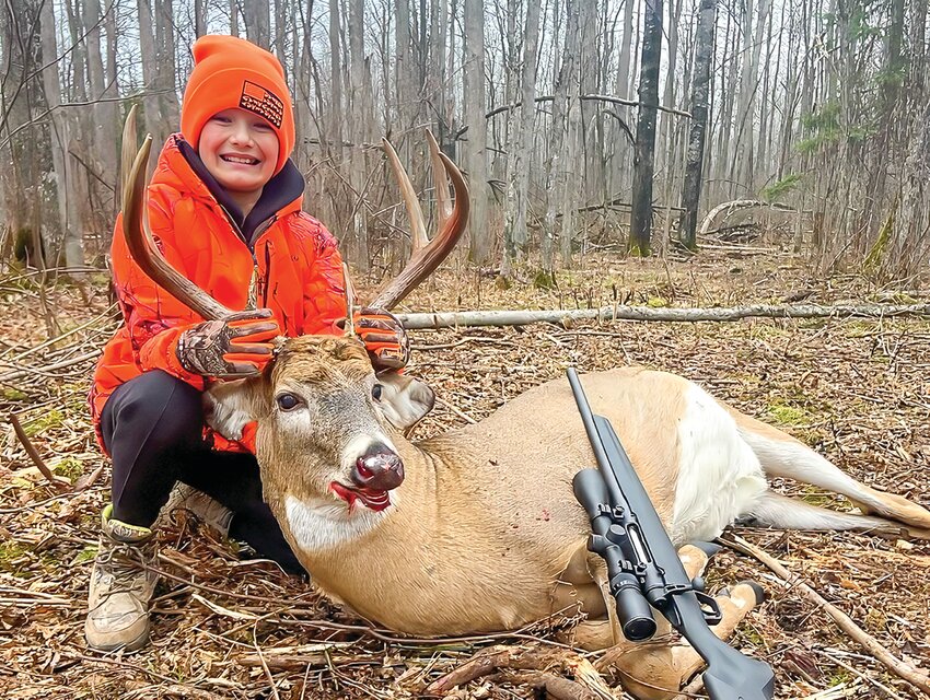 Brex McCormick poses with the eight-point buck he shot while hunting with his father north of Cook two weekends ago.