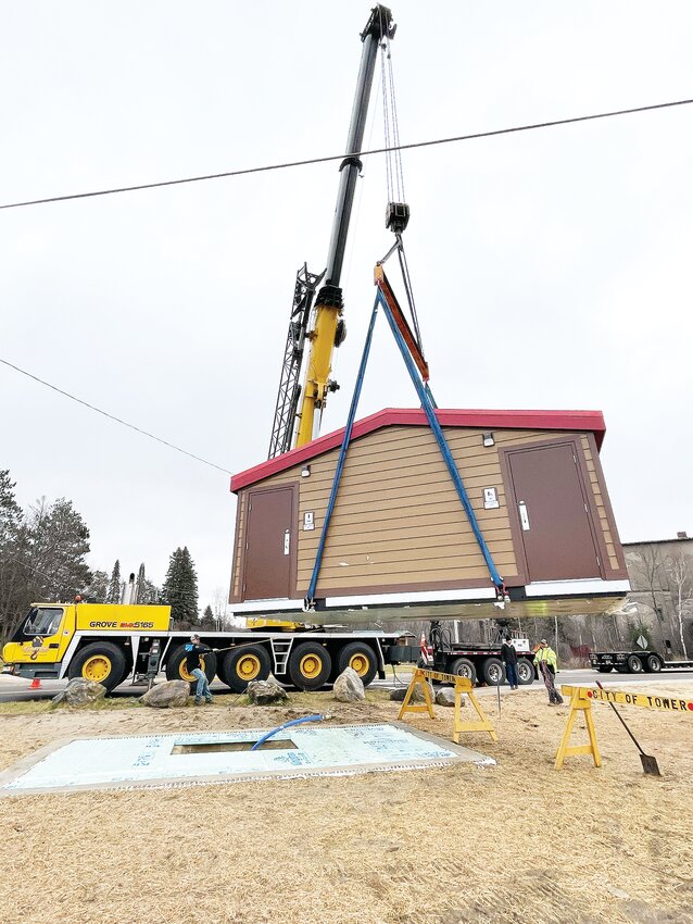 Moving the new restroom into place.at the Tower trailhead and mini-park.