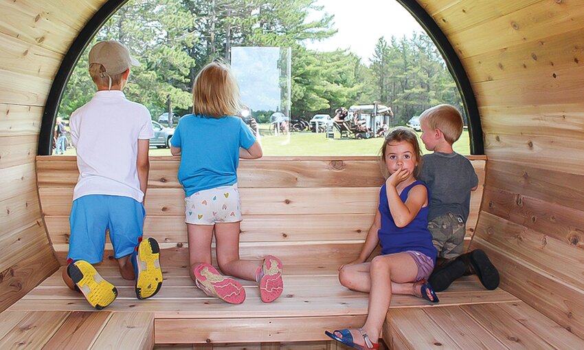 Edwin Swanson, Dot Swanson, Ellie Jankowski and Logan Jankowski enjoy the view in this barrel sauna made by Nordic Legend Products of Cloquet.