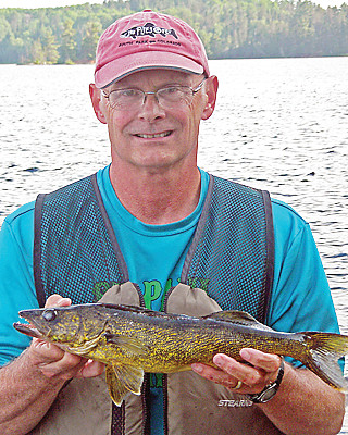 Tom Landwehr holds a walleye during his eight-year tenure as DNR Commissioner