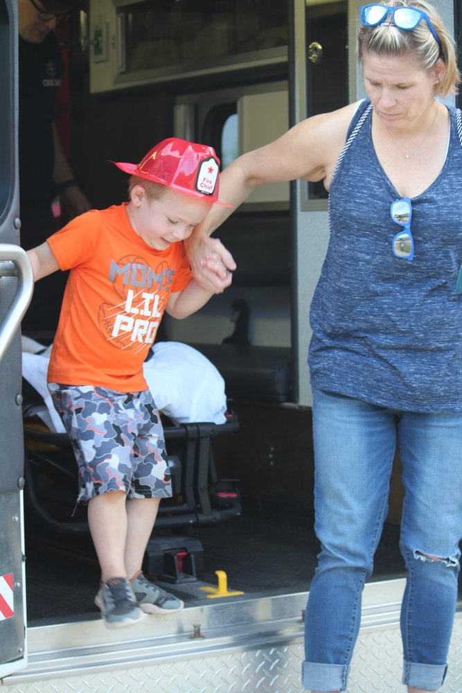 Caroline Roesch helps son Sullivan, 4, of Cook out of the ambulance after he explored the rig.