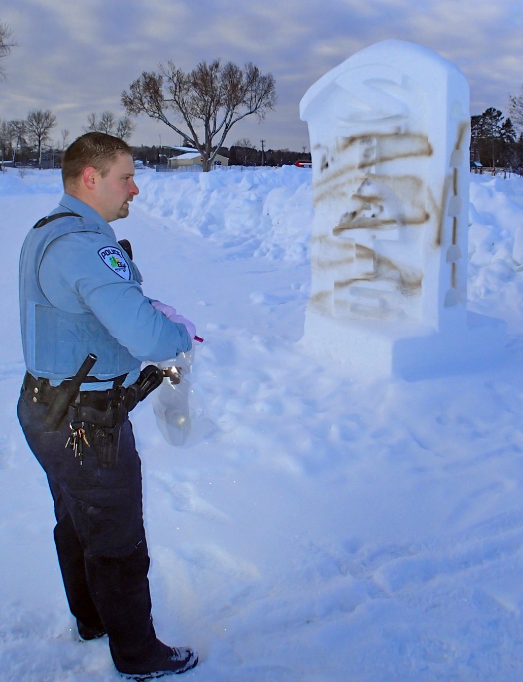 Ely Police patrolman Adam Borchert assesses damage to snow sculptures in Whiteside Park.