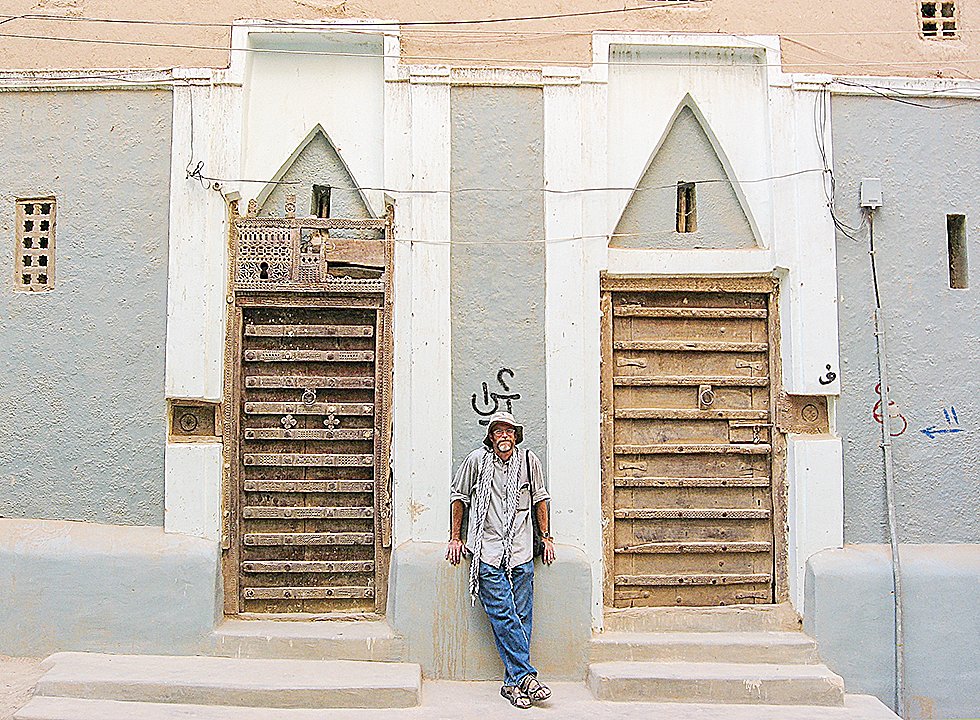 David Stanton stands between the doors of a mud brick “skyscraper” in Shebam, a town in the Hadramaut region of Yemen.