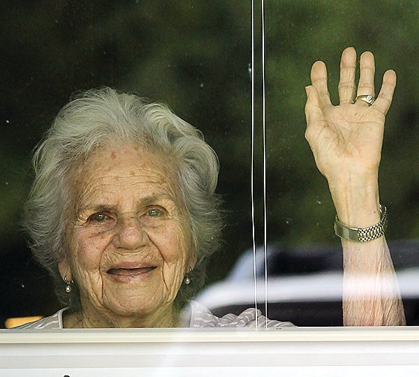 Ely Carefree Living resident Barbara Kollar waves from the window of her room.