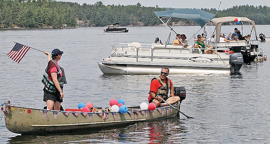 Andy and Sarah Levar show the colors during a July 4 flotilla on Burntside Lake.