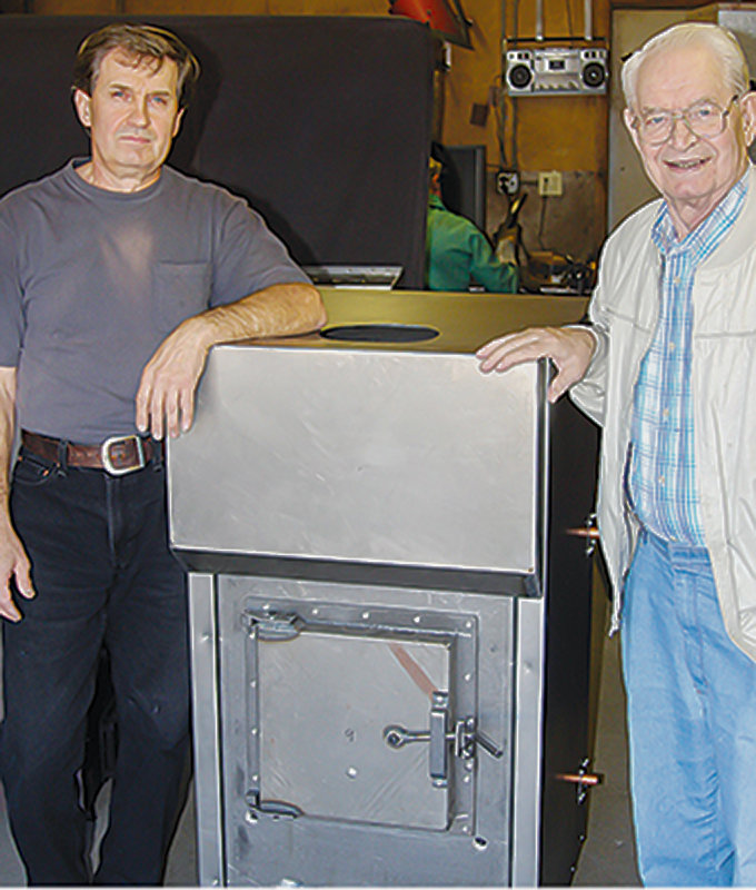 Daryl and Herb Lamppa with their wood-buring stove. The manufacturing company is located in Tower.