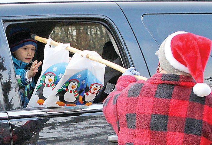 One of Santa’s elves hands out gift bags