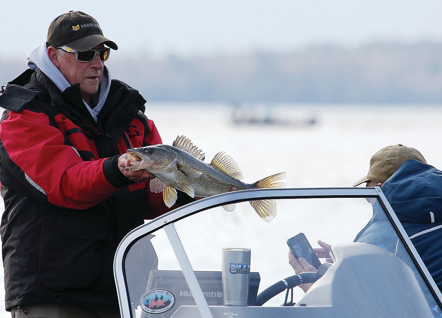 A Lake Vermilion angler hoists a nice walleye for his friend’s camera during a 
recent fishing opener.