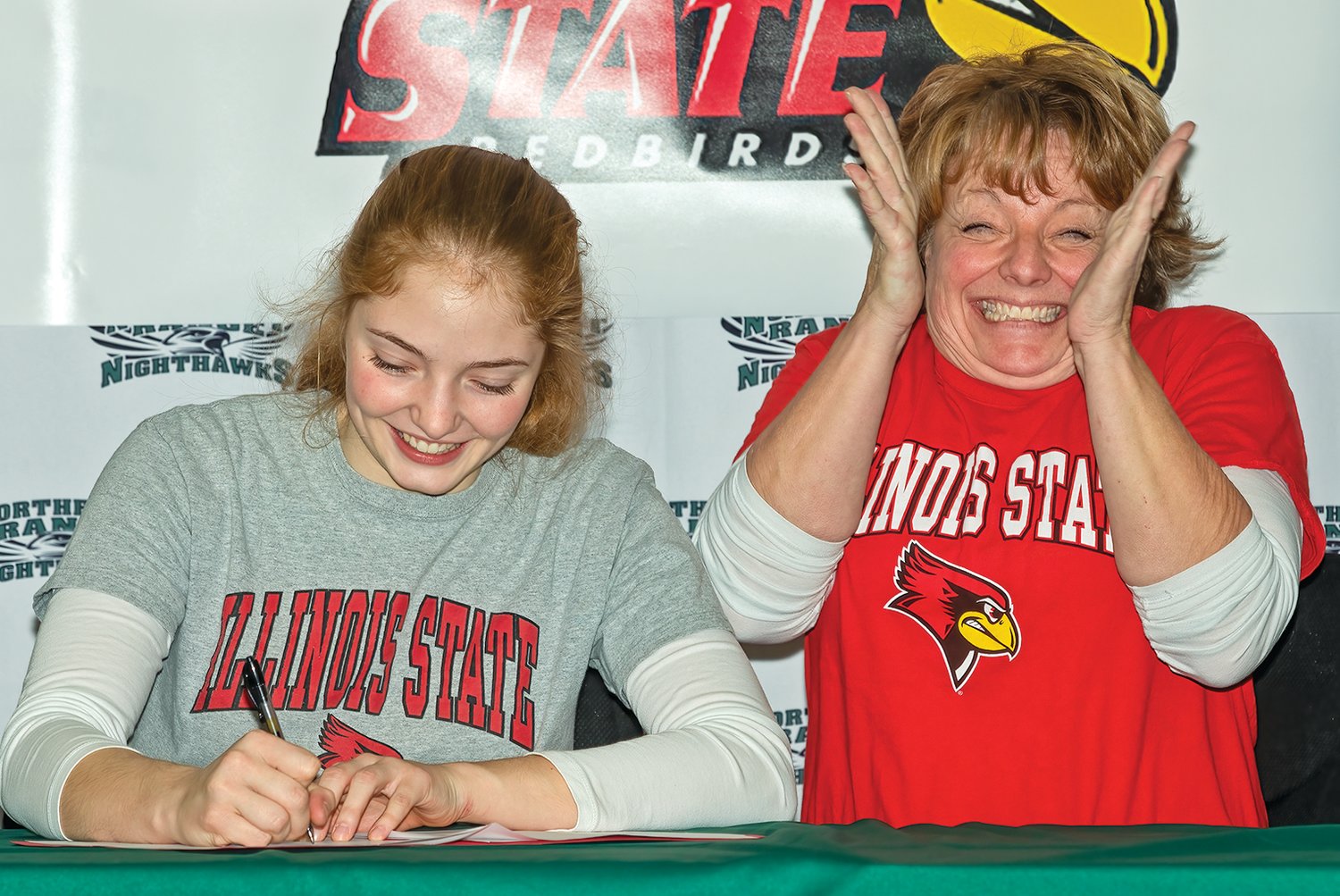 Hannah Reichensperger smiles as she signs her letter of intent to play for Illinois State. Meanwhile, her mom and coach, Jodi, can barely contain her excitement.