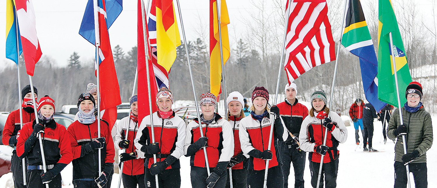 The Ely High School Nordic ski team participated in a flag parade at the opening day celebration.