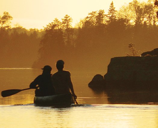 Canoeists head into the setting sun on waters within the upper Rainy River watershed. Those waters will be protected for the next 20 years under a decision announced Jan. 26.