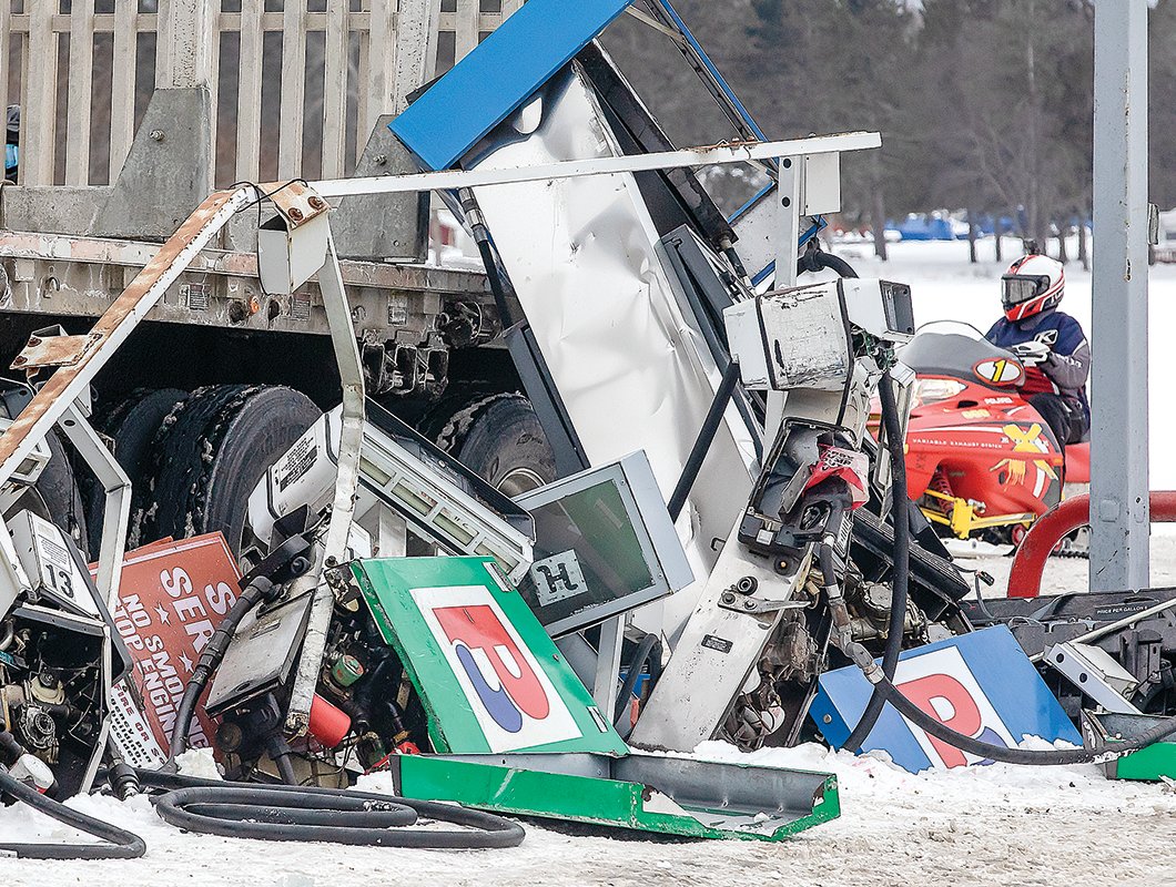A snowmobile surveys the damage at the fuel pumps at Pelican Bay Foods in Orr last Friday after a logging truck wiped out a line of gas pumps.