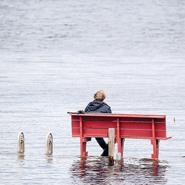 A solitary 
fisherman gazes out on Lake Kabetogama from a bench on a 
submerged boat dock on Saturday. The dock is normally two to three feet above lake level.