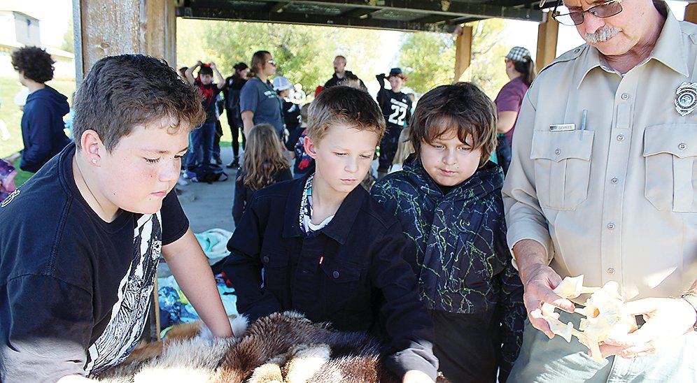 Boys inspect a variety of animal skins on display, while the DNR’s Jim DeVries looks on.