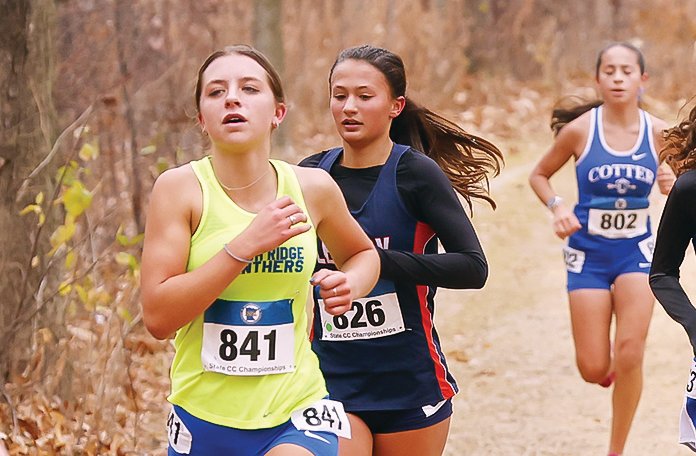 Evelyn Brodeen, in yellow jersey, runs near the front of the pack during last Saturday’s state meet in Northfield.