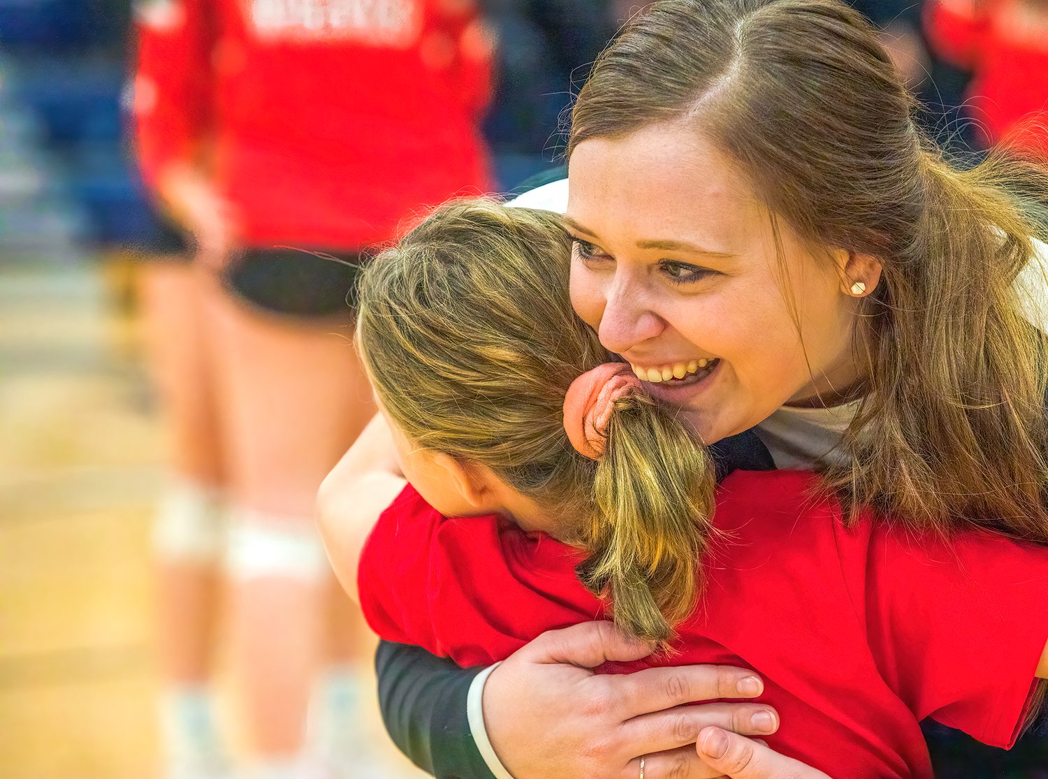 Ely Head Coach Megan Wognum gets a hug from second-grader Kaelyn Puzel after the match.