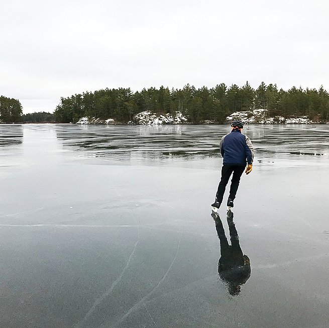 Skating away on Burntside Lake on dark, clear ice.