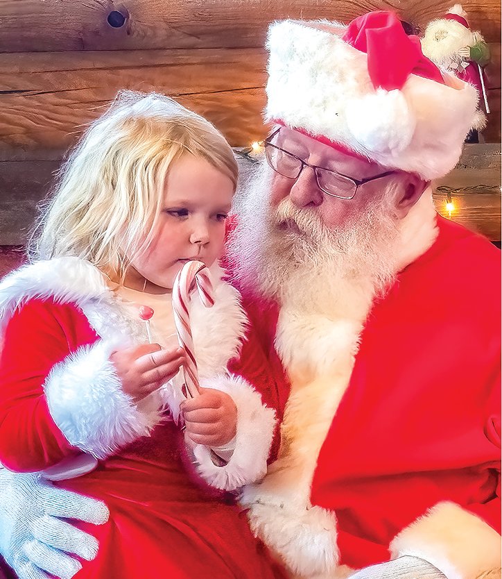 Fae Laakkonen-Gaylord listens as Santa asks if she's been good during his weekend stopover in Orr for the Snow City Christmas celebration.