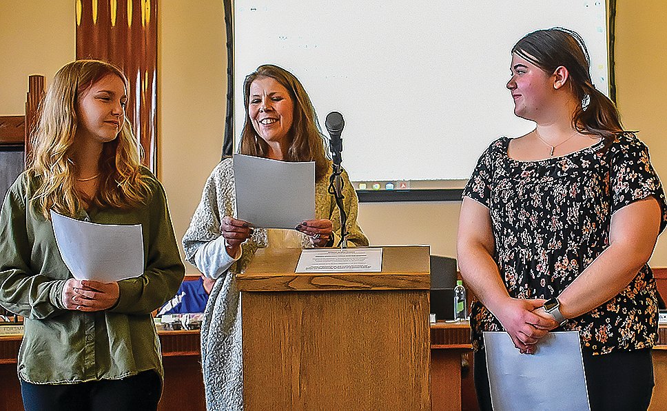 Mayor Heidi Omerza  (center) with Alison Poppler from Ely Memorial High School and Ruby Milton from Northeast Range High School, reading the proclamation.