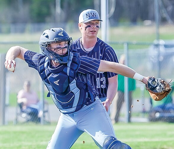 North Woods’ catcher Ben Kruse fields a bunt with pitcher Louie Panichi 
in the background.