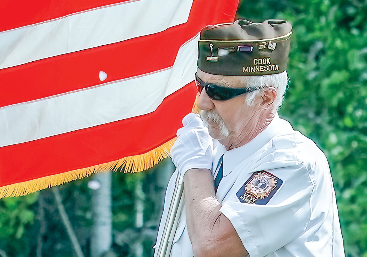 Jim Taylor with the Cook VFW displays the colors during a Memorial Day event in Cook on Monday.