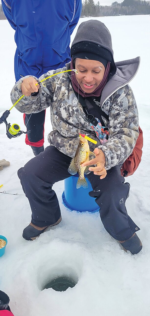One of the participants in the program smiles while landing a small crappie.