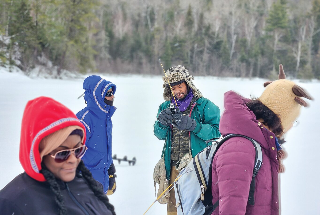 Kesley Ebbs (center) prepares an ice-fishing pole for one of the participants in this past winter’s outdoor experience made possible by Ebbs’ new 
outdoor adventure organization.