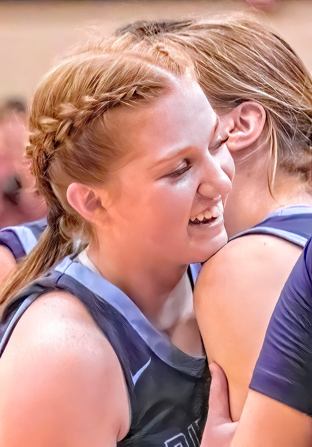 Helen Koch smiling as she receives a congratulatory hug from a teammate.