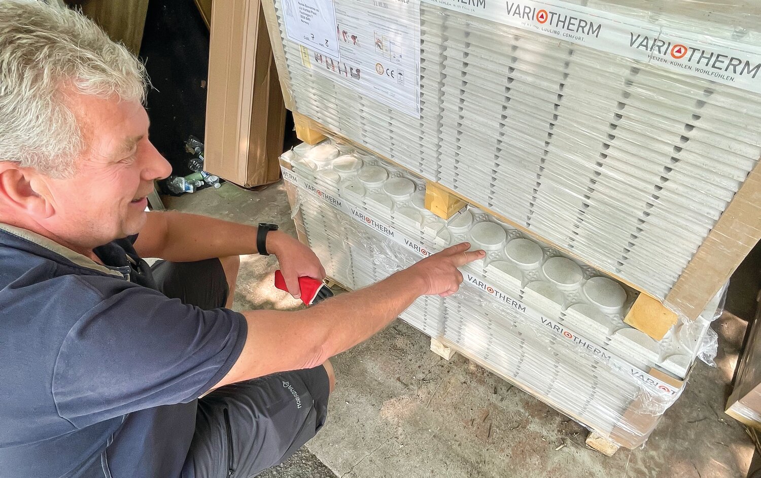 Norsk BioVarme CEO Arne Weggum points to the in-floor heating panels that he uses in his solar-powered home heating system.