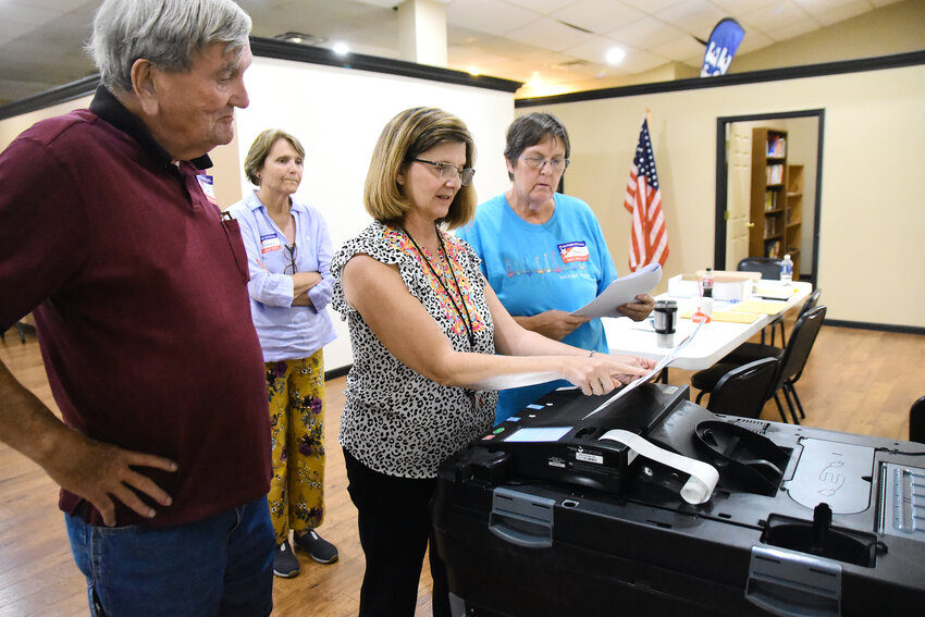 Ward 1 election judges (from left) Jim Diestelkamp, Barb Borcherding, Carol Keller, and Susan Fitzpatrick review shut-down procedures after the 7 p.m. closing Aug. 6 of the new polling precinct at Seasons of Faith Church. The Primary Election was the first election the four had worked where any of them had been responsible for closing down a voting precinct.