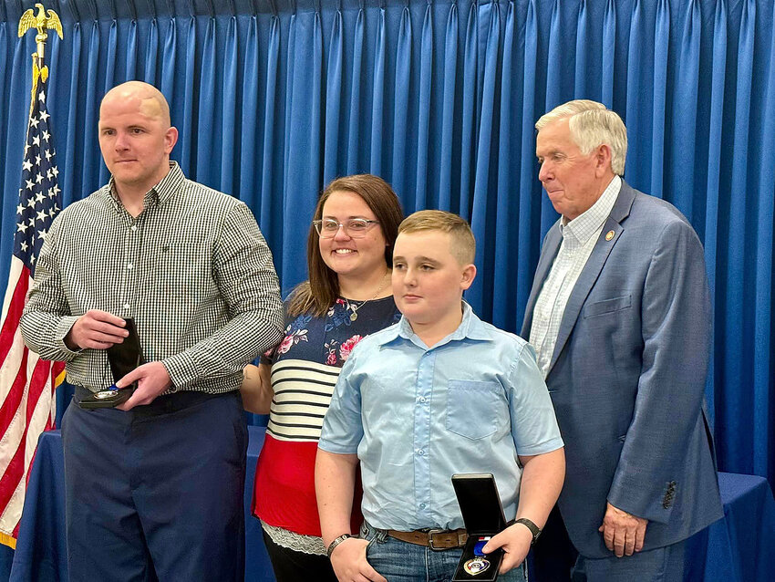 WOUNDED HERMANN police patrolman Adam Sullentrup, and Jennifer and Karson Griffith are pictured Thursday with Gov. Mike Parson after he presented Red, White and Blue Heart Awards to Sullentrup and the late Det. Sgt. Mason Griffith.