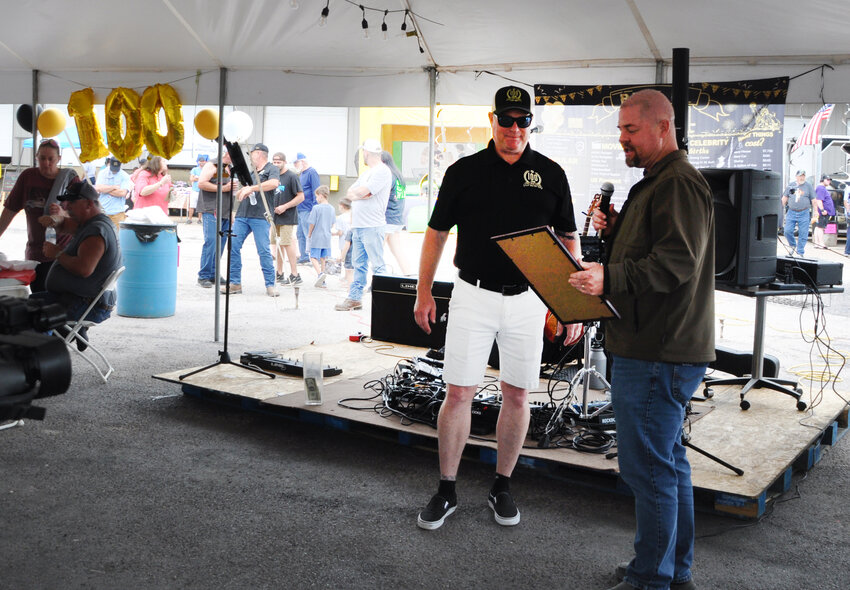 Rep. Brad Banderman, District 119 (right) reads aloud a resolution applauding the long, productive history of the Woody Bogler Trucking Company.  He then presented a framed copy of the resolution to Tracy Bogler, owner of the company.