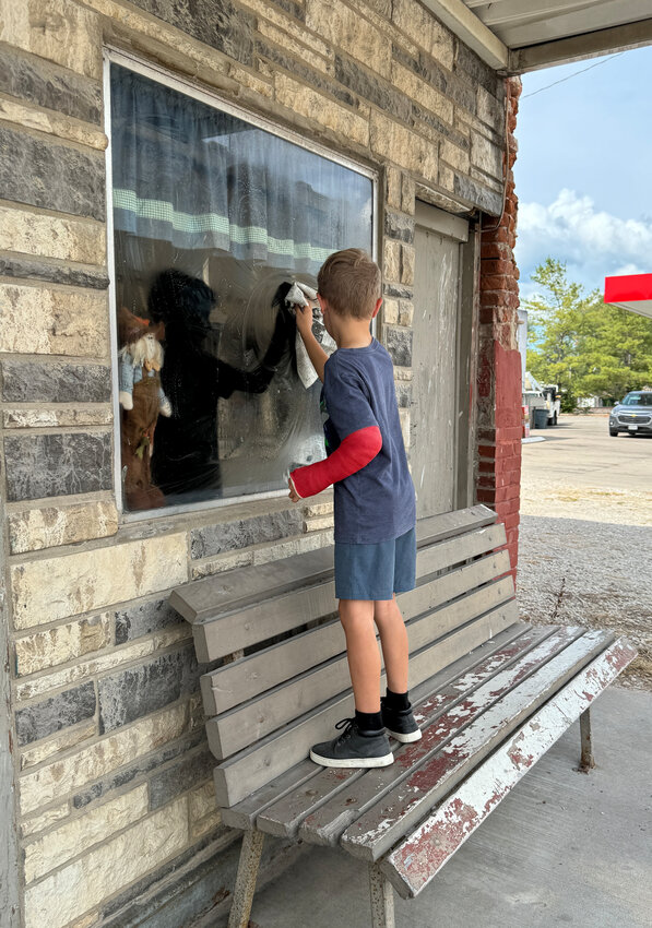 Connor Alexander washes windows at a building on Main Street in preparation for Chamois Day, which will be held on Saturday.