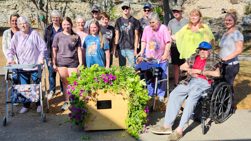 Gasconade County 4-H Club members helping create planter boxes included Sabrina Korman (Town & Country 4-H Club), Kalina Coon (Double S 4-H Club), Evan Korman (Town & Country 4-H Club), Dakota Coon (Double S 4-H), and Wyatt Korman (Town & Country 4-H). Stone Bridge resident and staff members are pictured with area 4-H members Kalina Coon (Double S 4-H), Sabrina Korman, (Town & Country 4-H), Evan Korman (Town & Country 4-H), Wyatt Korman (Town & Country 4-H),Chase Willimann, (Double S 4-H), Kolton Willimann (Double S 4-H), and Dakota Coon (Double S 4-H). A placard is attached to the planter boxes listing all businesses that generously donated materials and supplies for this project.