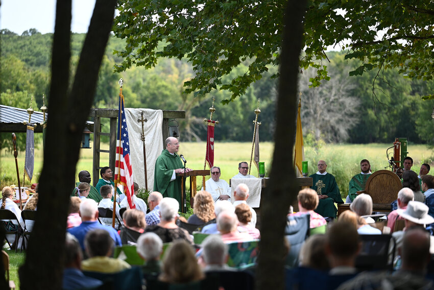 Bishop W. Shawn McKnight (above), surrounded by eight concelebrating priests and about 350 people from parishes all over the Jefferson City diocese, preaches the homily during the diocese’s inaugural Rural Life Mass Sept. 8 on the Steinman Family Farm near Vienna. Congregants were seated on lawn chairs, blankets or hay bales under shade trees or the late-summer sun.