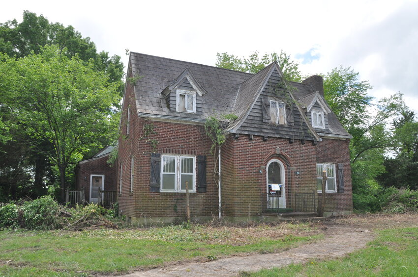 Dr. Charles Schmidt’s home is being released from years of encroachment from brush and vines (above, left). The Rock Island Bloomers have undertaken the job as one of their beautification projects and are making good progress (above, right).